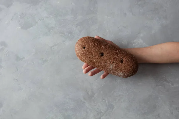 Женщина держит буханку хлеба за руку — стоковое фото