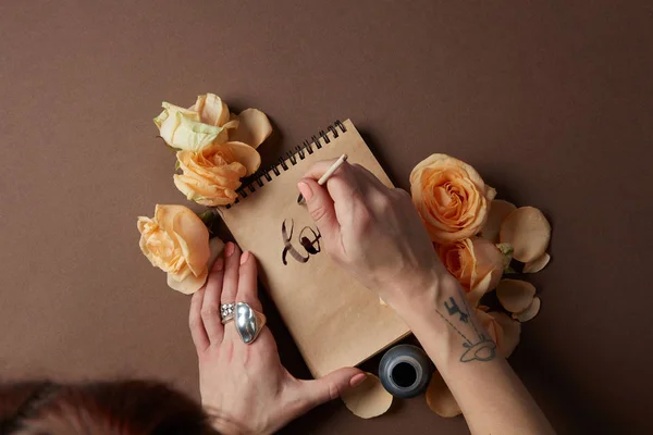 Mujer escribiendo en bloc de notas artesanal — Foto de Stock