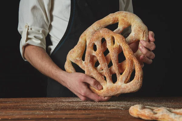 Baker drží Francouzské Fougy chléb — Stock fotografie