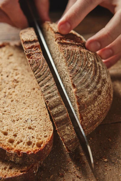 Female hands cutting bread — Stock Photo, Image