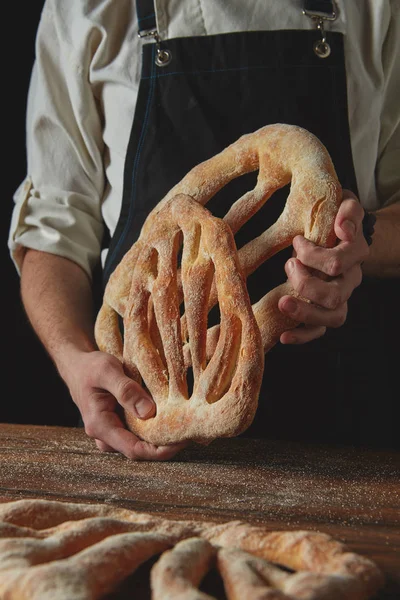 Mani del fornaio che tengono il pane fougas — Foto Stock