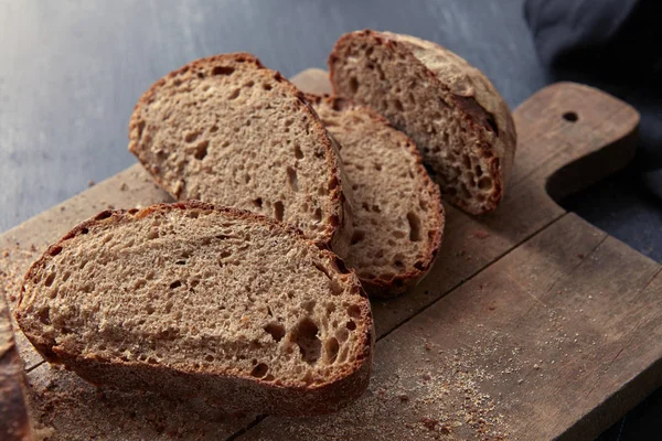 Gesneden brood op houten plank — Stockfoto