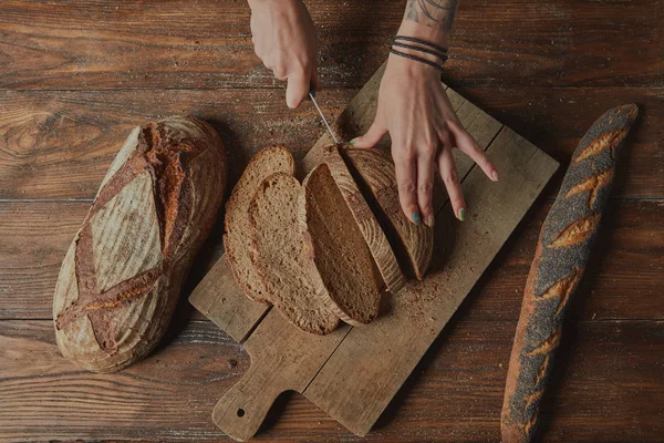 Kobiecych rąk z krojonego chleba — Zdjęcie stockowe