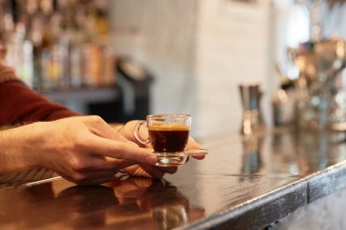 Ellerin kahve bardağını tutuyor.