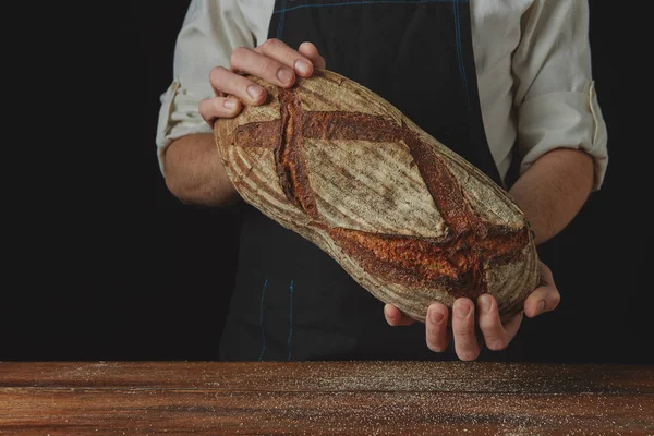 Hombre sosteniendo pan fresco ovalado —  Fotos de Stock