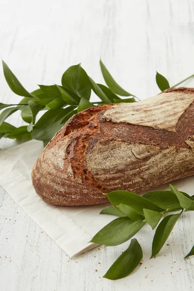 Fresh bread with branches of leaves — Stock Photo, Image