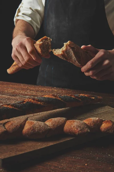 Male hands breaking baguette — Stock Photo, Image