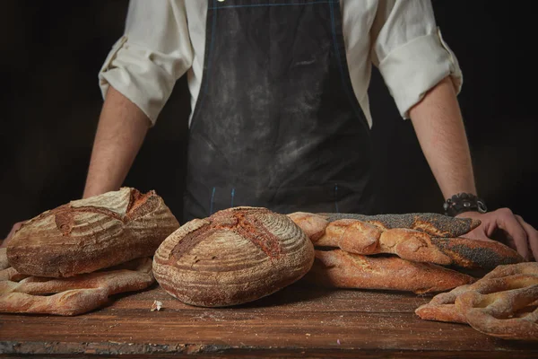 Panettiere in grembiule con pane fresco — Foto Stock
