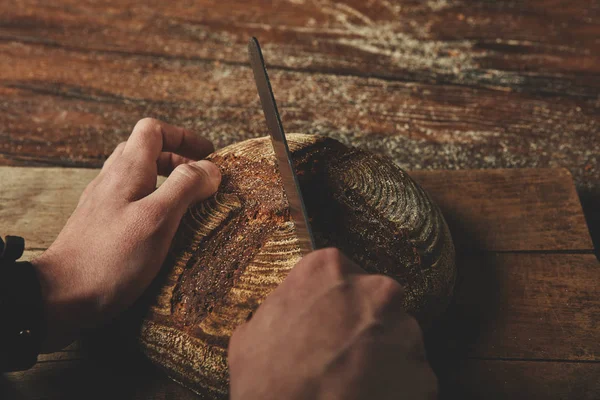 Muž krájí chutný čerstvý chleba — Stock fotografie