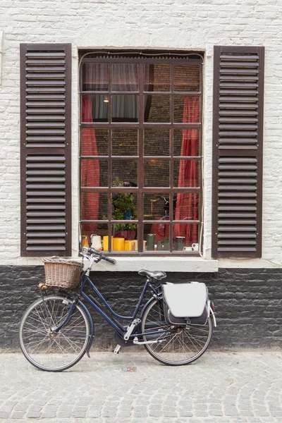 Fiets in de buurt van venster in Brugge — Stockfoto