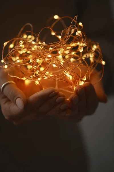 Manos Femeninas Sosteniendo Guirnalda Eléctrica Luces Navidad Sobre Fondo Oscuro — Foto de Stock