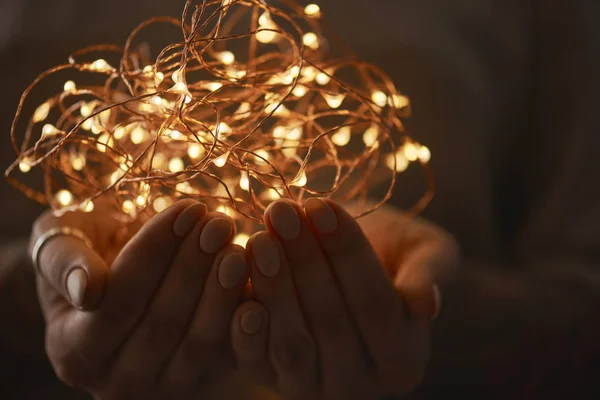 Mãos Femininas Segurando Guirlanda Elétrica Luzes Natal Fundo Escuro — Fotografia de Stock