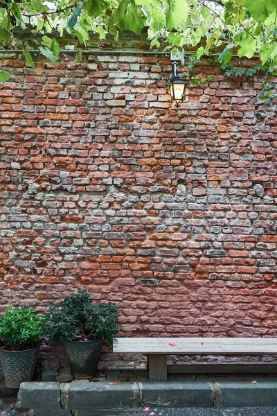 Eski Tuğla Duvar Arka Plan Karşı Asma Bank Yeşil Çalılar — Stok fotoğraf