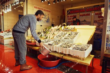 Istanbul, Türkiye - Kasım 25,2017: balık Pazar Istanbul'da. Balık su dökülen adam