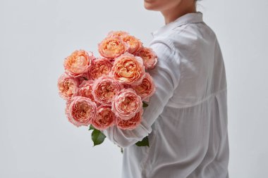 Pembe gül buketi tutan kadının fotoğrafını kırpılmış
