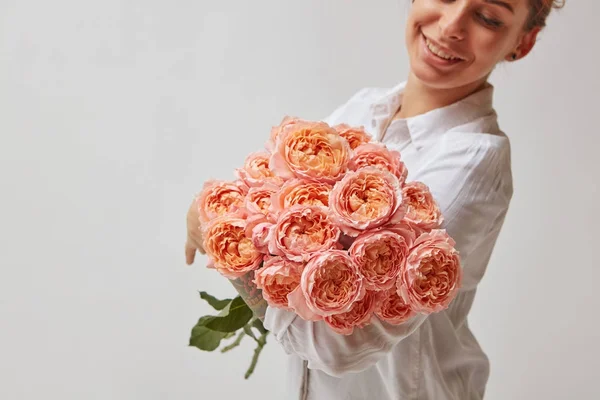 ピンクのバラの花束を持って幸せな若い女の肖像 — ストック写真