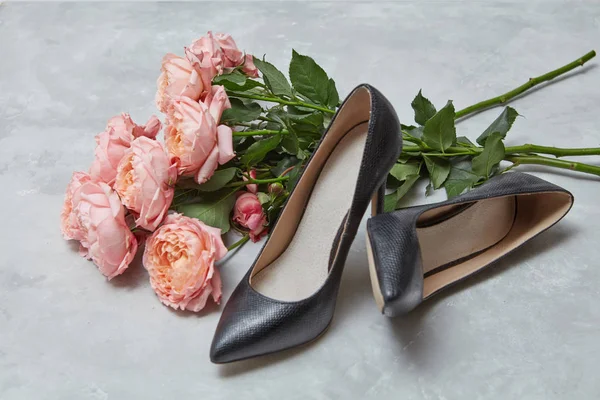 优雅的黑色女性鞋和粉红色的玫瑰花在灰色背景 — 图库照片