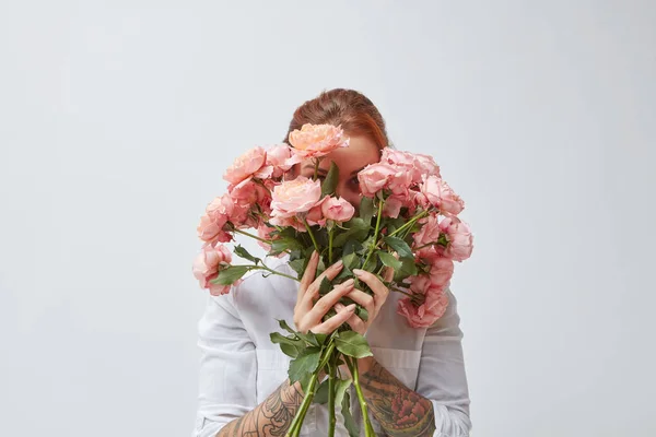 グレーの背景にピンクのバラの花束を持って 母の日の概念を覆っている若い赤髪の女 — ストック写真