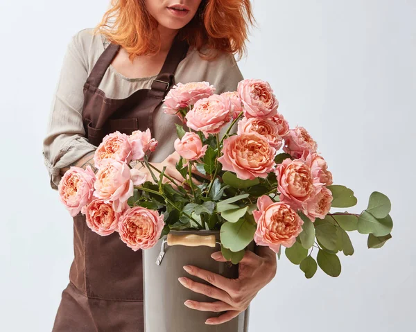 Счастливая Молодая Рыжая Женщина Фартуке Держа Вазу Букетом Розовых Роз — стоковое фото