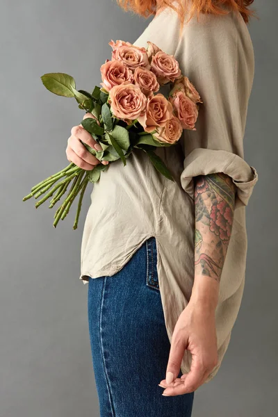 年轻女子捧着卡布奇诺玫瑰的花束反对灰色背景 母亲节概念 — 图库照片
