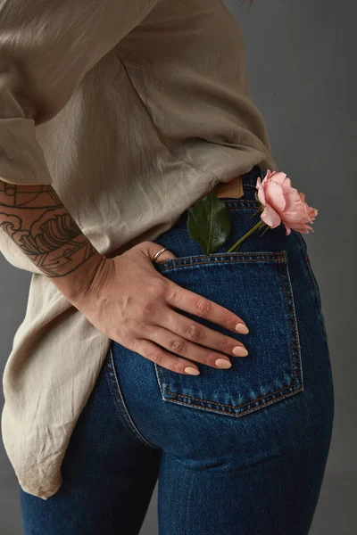 Kvinnan Blå Jeans Med Rosa Ros Rygg Ficka Mot Grå — Stockfoto