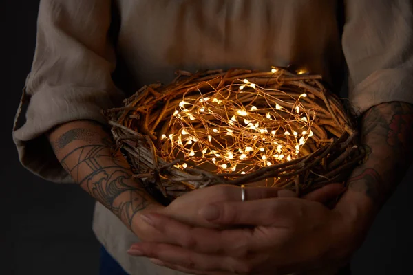 Frau Hält Nest Mit Elektrischem Lichterkranz Auf Dunklem Hintergrund Osterferien — Stockfoto