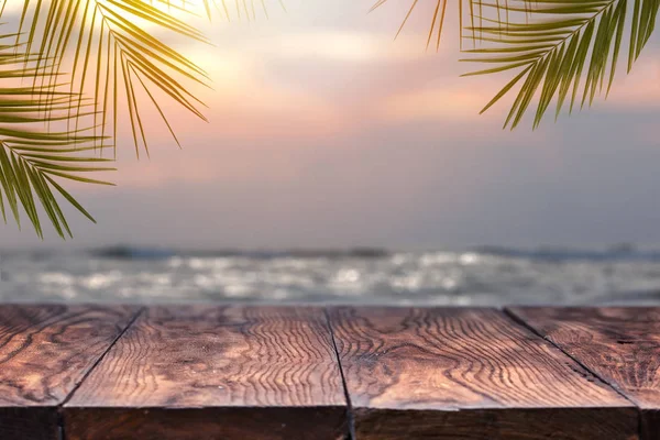 Holztisch Auf Dem Hintergrund Des Verschwommenen Sonnenuntergangs Meer Und Palmenblätter — Stockfoto