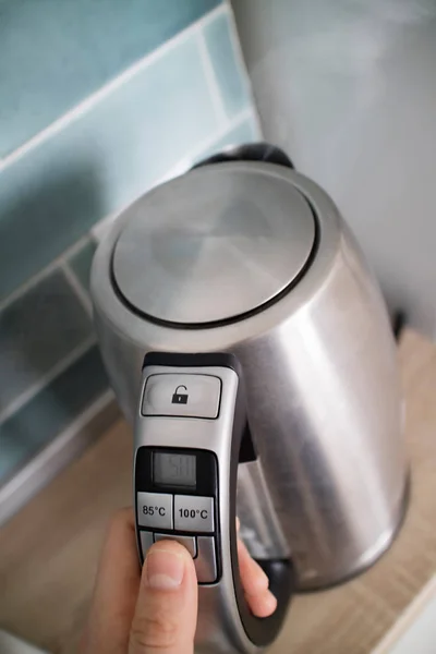 Мужская Рука Нажав Кнопку Питания Нержавеющей Электрический Чайник Кухонном Фоне — стоковое фото