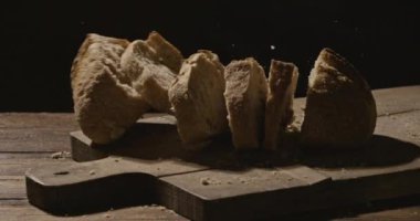  ahşap masa, ağır çekim atılan taze ekmek dilimleri 