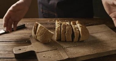 atma adam ahşap masa, ağır çekim taze ekmek dilimlenmiş 