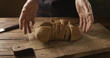 atma adam ahşap masa, ağır çekim taze ekmek dilimlenmiş 