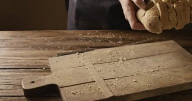 atma adam ahşap masa, ağır çekim taze ekmek dilimlenmiş 