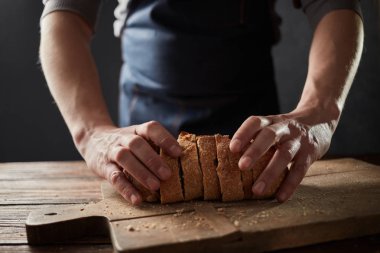 adam tutarak taze ekmek ahşap masa, ağır çekim dilimlenmiş. 