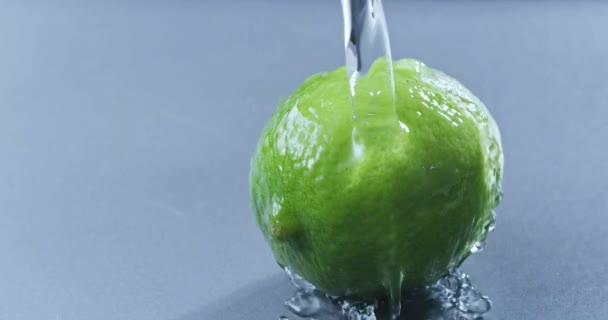 Water Being Poured Fresh Ripe Lime Blue Background — Stock Video