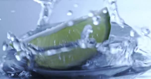 Morceau Lime Fraîche Tombant Sur Fond Bleu Avec Eau — Video