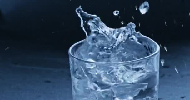 glaçons tombant dans un verre d'eau propre 