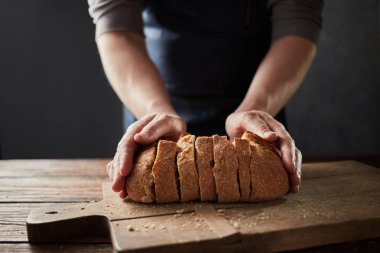 adam tutarak taze ekmek ahşap masa, ağır çekim dilimlenmiş. 