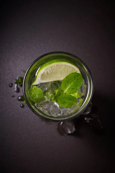黒い背景 冷たい夏の飲み物にアイス モヒート カクテルのグラスと成分 ライム ミントの葉します — ストック写真