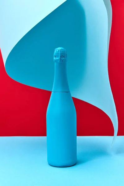 假日作画的蓝色葡萄酒的模拟瓶子在双色背景与折叠的蓝色纸 复制空间 — 图库照片