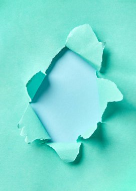 Pastel mavi arka planda yırtık bir turkuaz kağıttan kopyalanmış el yapımı çerçeve. Yaratıcılığın için kullanılabilir..