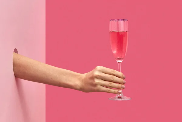 假日里 手中拿着一杯玫瑰酒 穿过墙壁上的洞口 在粉红色的双色背景上 有柔和的影子 复制空间 假日概念 — 图库照片