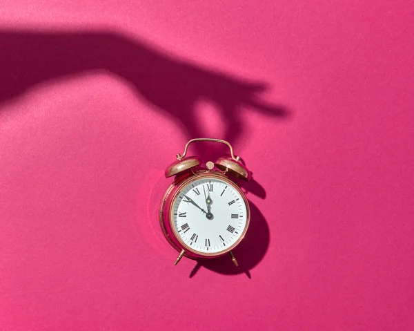 Ретро Купер Будильник Твердыми Тенями Женской Руки Горячем Розовом Фоне — стоковое фото