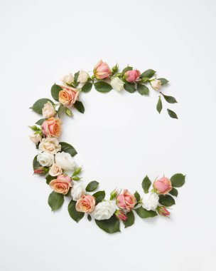 Çiçek açan köşe çiçekleri açık gri arka planda yeşil yapraklı mercan güllerinden giyinir. Kopya alanı. Düz yatıyordu. Sevgililer Günü konsepti.