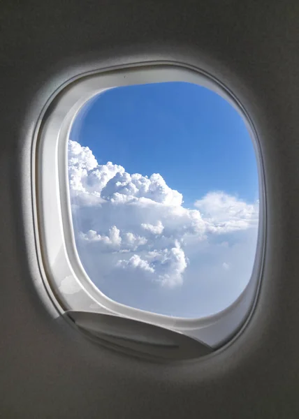 澄んだ青い曇り空の美しい空中ビューを持つ航空機の窓枠は コピースペースと日当たりの良いビームを点灯しました 交通機関の概念 ストック画像