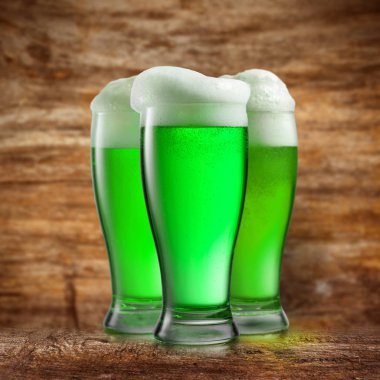 Natural green alcoholic beer drink on a wooden abstract blurred background with place for text. Happy St.Patrick 's Day concept.