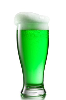 Closeup view of clear glass with fresh natural alcoholic beer drink and extra foam on a white background, copy space. Happy St.Patrick 's Day concept.