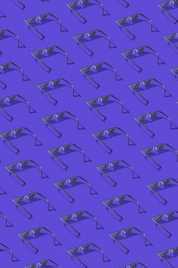 Defter ekranları, telefonlar ve koyu leylak arkaplanlı televizyonla çalışmak için kullanılan koruyucu bilgisayar piksel gözlüklerinden yaratıcı desen.