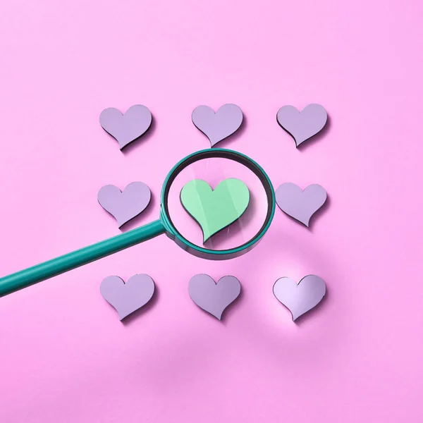 大きなルーペパステルピンクの背景に他のラベンダー色の心の周りの緑の心のサイズが増加している コピースペース バレンタインデーグリーティングカード — ストック写真