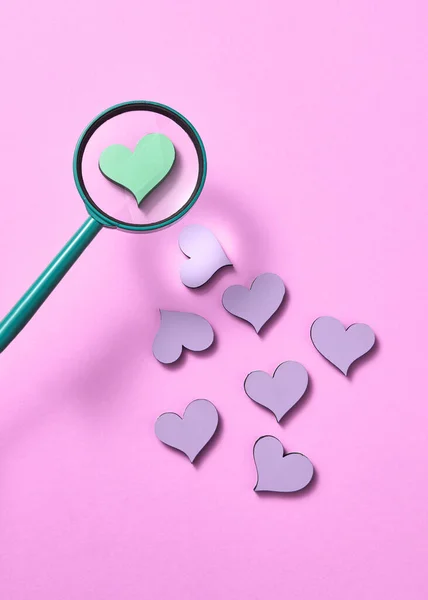 假日图案与小心脏和大放大镜上方的一个绿色心脏在粉红的粉刷背景 复制空间 情人节贺卡 — 图库照片