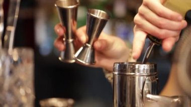 Barmen içkileri karıştırıcıya dolduruyor, yakın plan.